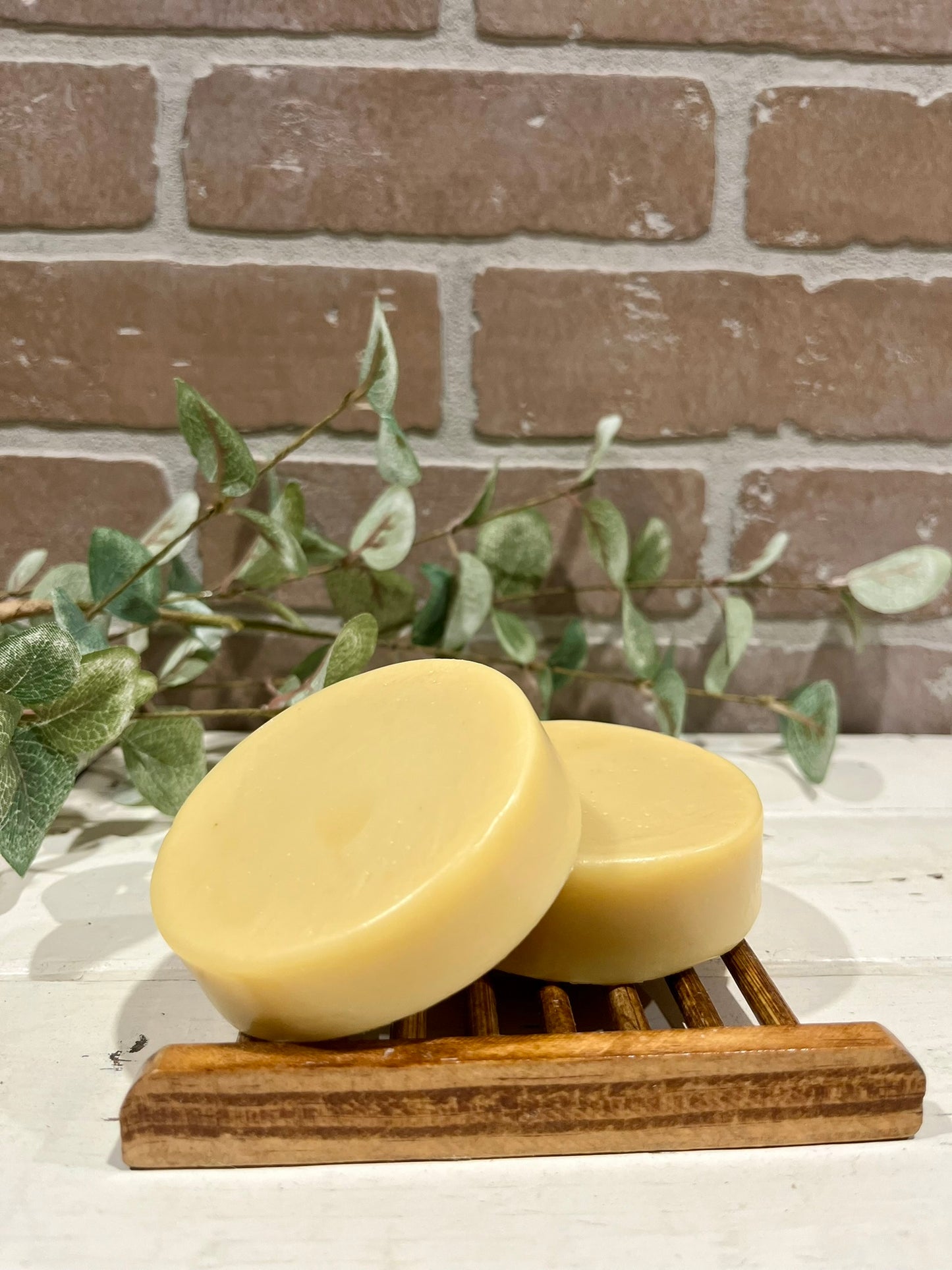 round face soap bars in front of a brick wall