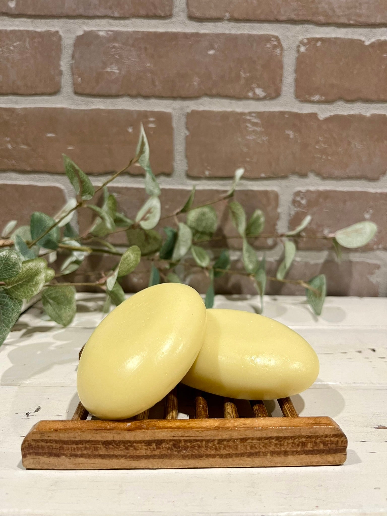 oval hair soap bars in front of brick wall